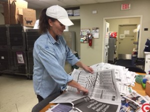 Sorting donated newspapers so dog and cat kennels can be quickly lined by staff and volunteers.